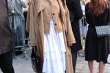 Mode-Ikone Alexa Chung wählt in Paris für die Runway Show von Loewe einen weißen Volants-Rock zum Klassiker im Herbst: dem Trenchcoat. 