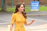In einem strahlenden Gelb zeigt sich Prinzessin Catherine von Wales bei einem Besuch des Royal Surrey County Hospitals in Guildford. Das Midikleid mit Taillengürtel kombiniert Kate mit blauen Wildleder-Pumps und passender Clutch. Die Tasche harmoniert außerdem toll mit dem blauen Saphir ihres Verlobungsringes – ein Schmuckstück von Lady Diana.