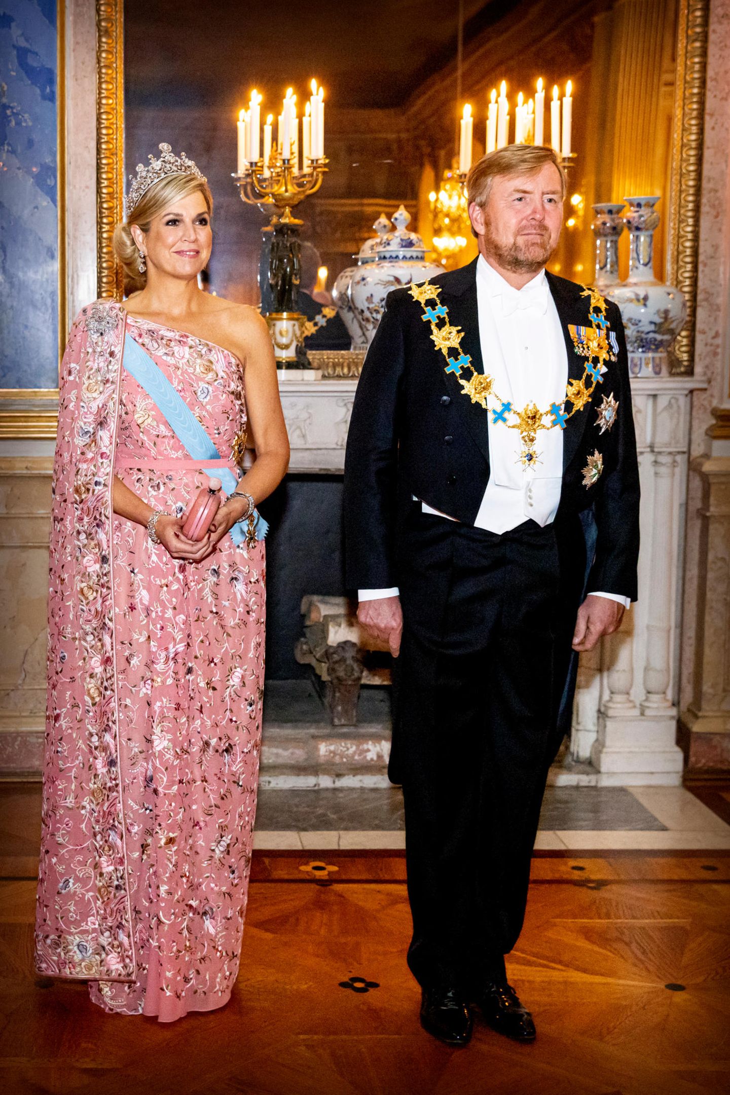 Ebenso glamourös, jedoch in etwas softerer Farbe, zeigt sich Königin Máxima beim Staatsbankett in Schweden. Die 52-Jährige strahlt in einer rosafarbenen One-Shoulder-Robe mit Blumenstickereien von Jantaminiau. Dazu kombiniert sie "Evita"-Plateausandalen von Aquazzura sowie ihre Stuart Tiara. 
