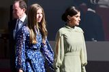 Am Nationalfeiertag präsentieren sich Königin Letizia und Prinzessin Sofia gemeinsam bei der Militärparade. Die Königin setzt auf ein hellgrünes Kleid mit Pünktchen von Vogana, welches durch einen auffälligen Kragen sowie dezente Schlitze an den Armen besticht. Bei ihren Schuhen und der Handtasche setzt sie auf ein paar Lieblinge aus ihrem Kleiderschrank, die wir schon häufiger an ihr bewundern durften. 