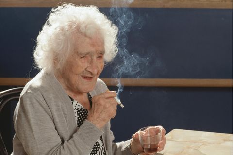 Jeanne Calment genießt an ihrem 117. Geburtstag ihre tägliche Zigaerette und ihr Glas Portwein 