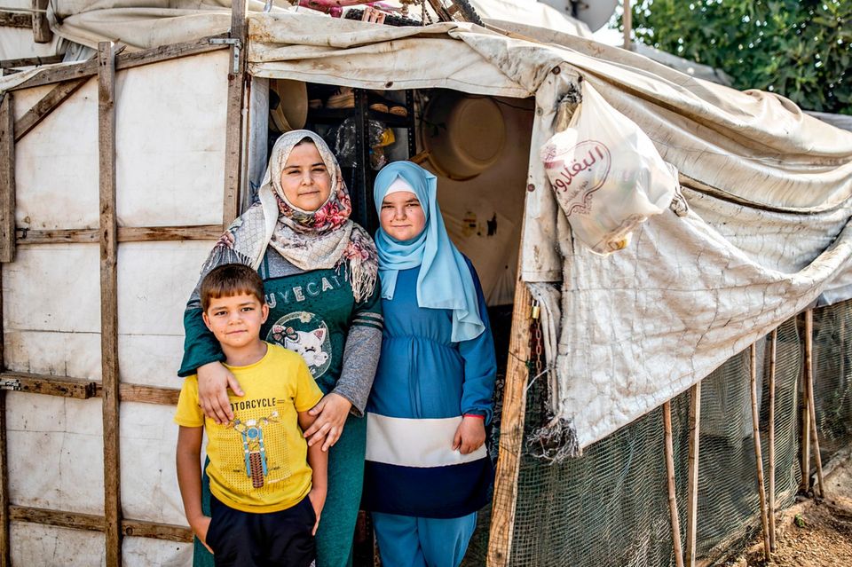 Ein Schal fürs Leben 2022: eine Mutter steht mit ihrem beiden Kindern vor einem Zelt