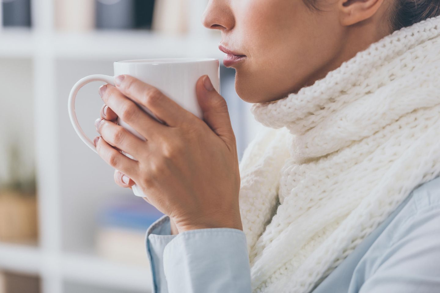 Schluckbeschwerden: Frau mit Halsschmerzen trinkt Tee