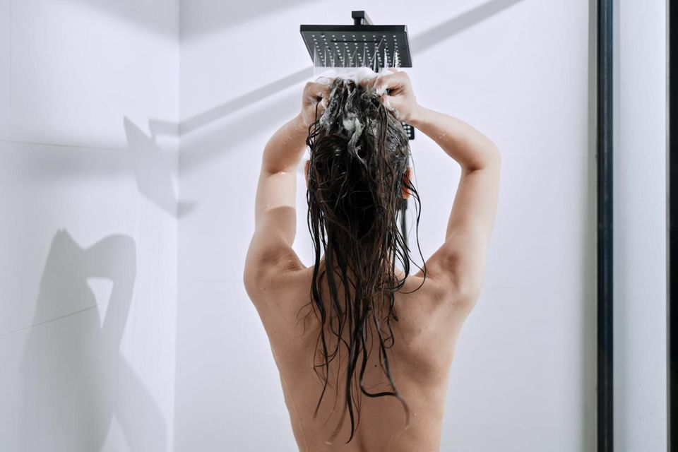 Frau unter der Dusche: Ist es besser, morgens oder abends zu duschen?