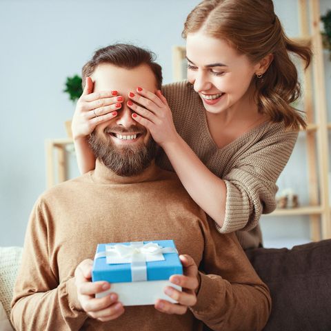 Frau überreicht Geschenk, glückliches Paar, nachhaltige Geschenke