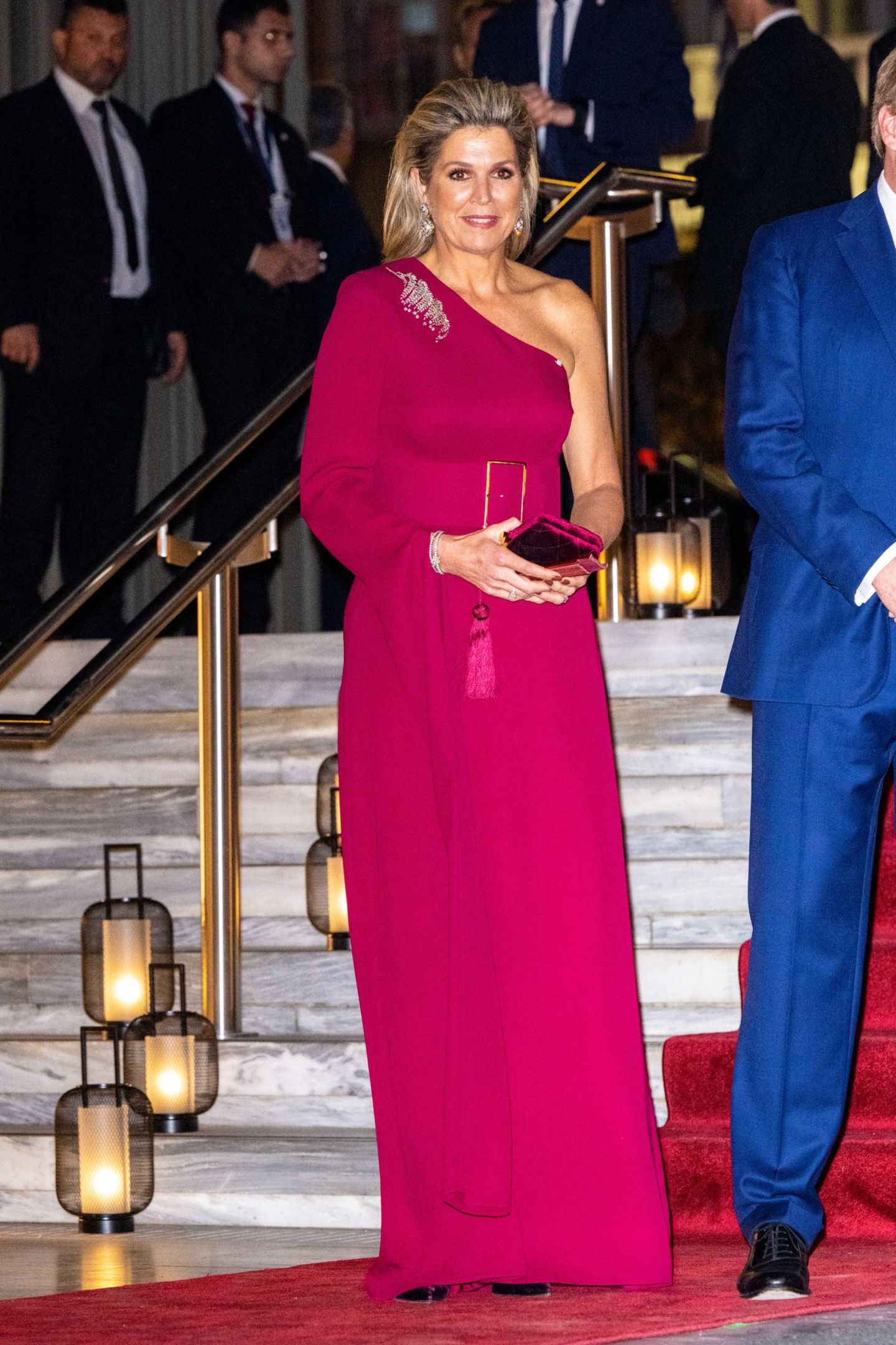 Eintönig, aber nicht langweilig! Am dritten Tag ihres Staatsbesuchs in Griechenland beweist Königin Máxima, wie königlich-schick Laufsteg-Trends aussehen! In einem völlig monochromen Outfit, wie es für den Herbst und Winter 2022 bereits auf den Laufstegen von Valentino oder Max Mara zu sehen war, zeigt die Niederländerin ihr Modegespür. Dabei hält sich die 51-Jährige an ein knalliges Burgunder: Ein bodenlanges One-Shoulder-Kleid von Claes Iversen betont mithilfe eines Gürtel ihre wunderschöne Taille, während sich die passende Clutch und die feine Brosche perfekt in den Look integrieren. 