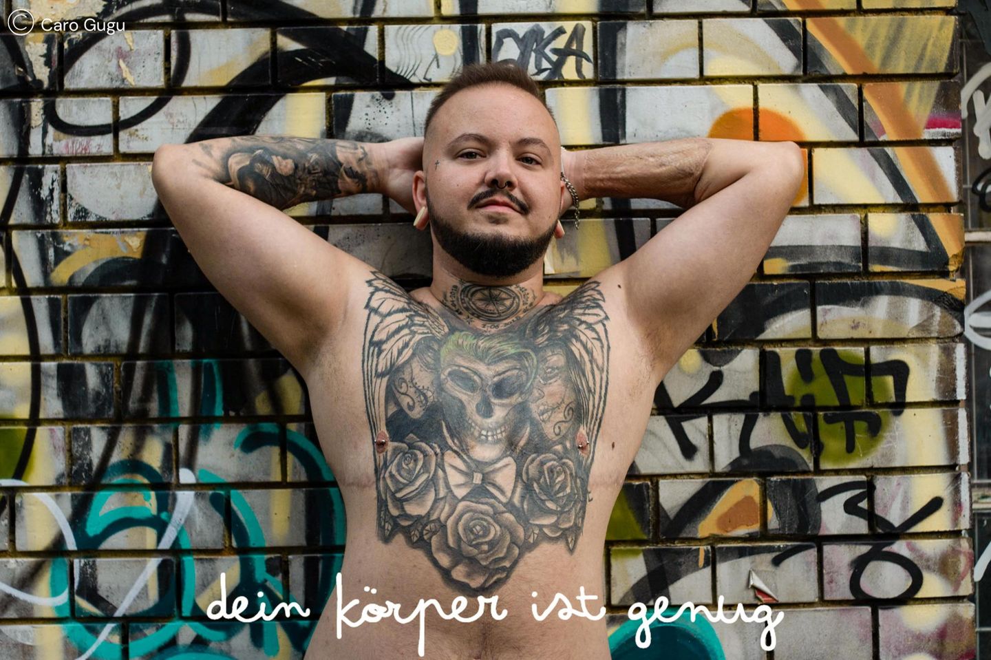 Dein Körper ist genug: Mann lehnt gegen eine Mauer