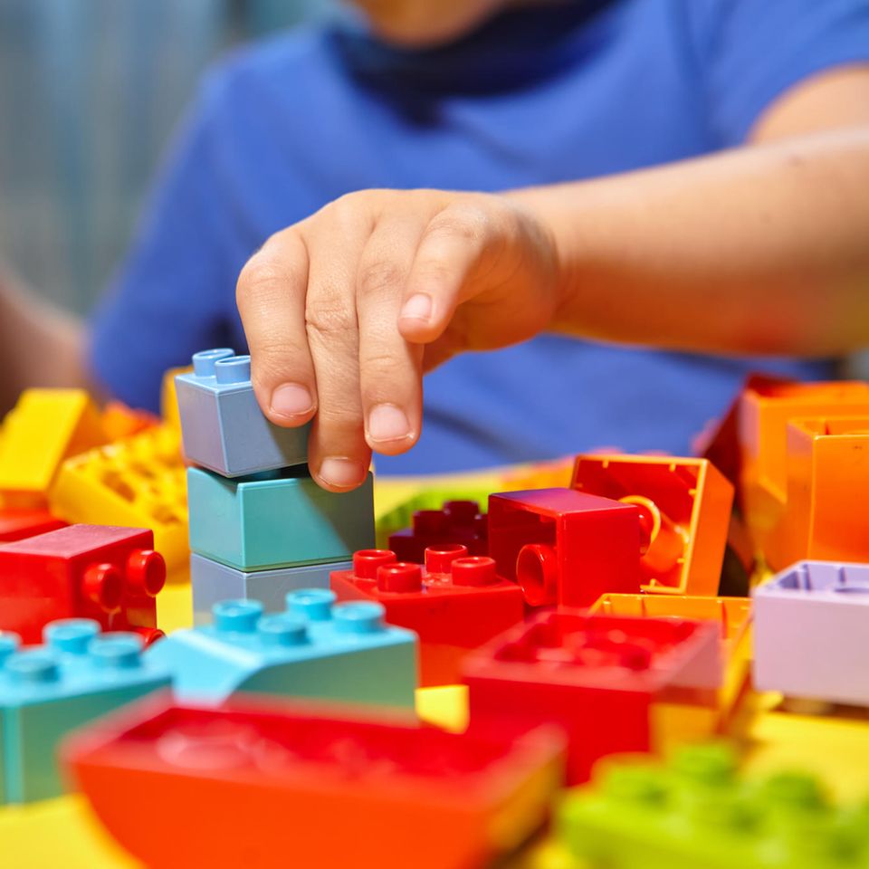 Plastikspielzeug: ein Junge spielt mit Lego Steinen