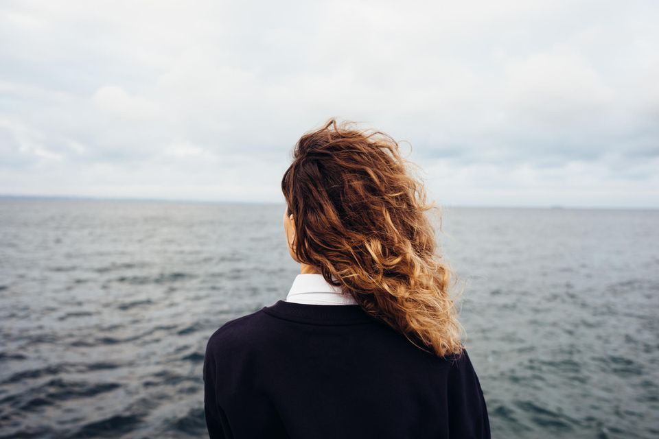 Frau schaut nachdenklich aufs Meer: Dieser Fehler könnte dich daran hindern, deine Ziele zu erreichen