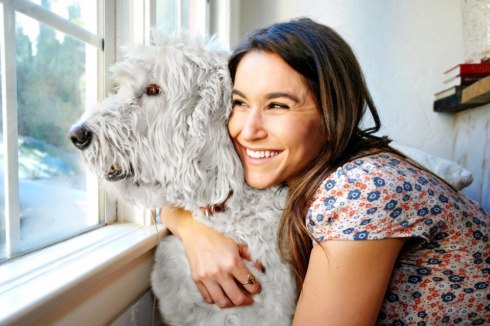 Hunde für Allergiker: Eine Frau umarmt einen Hund.