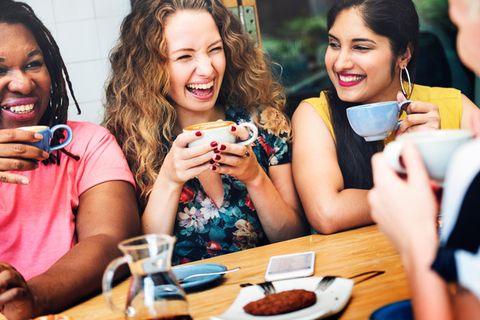 Frauen trinken gemeinsam Kaffee und führen lachend ein Gespräch