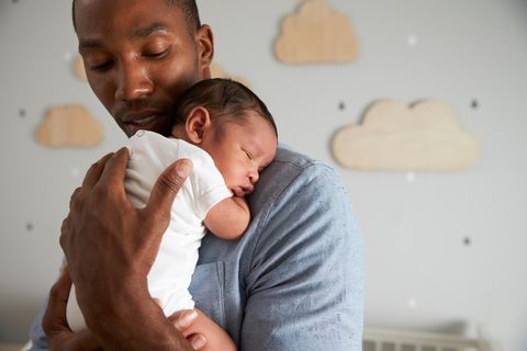 Bezahlte Freistellung: Vater hält Baby auf dem Arm