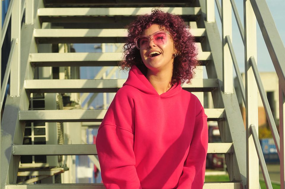 Trendfarbe Viva Magenta: Mit der Farbe des Jahres startet ihr 2023 durch, junge Frau mit strahlendem Lachen