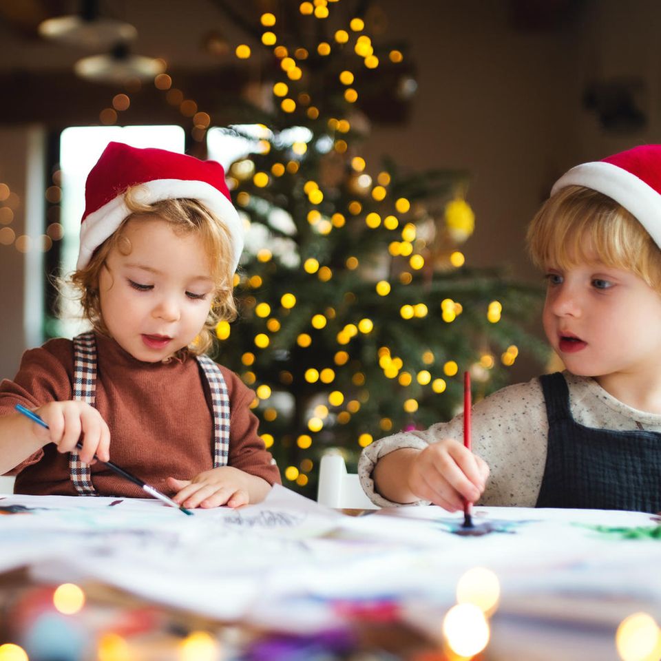 Wenn Kinder Weihnachten erklären: Zwei Kinder malen zusammen Weihnachtsbilder