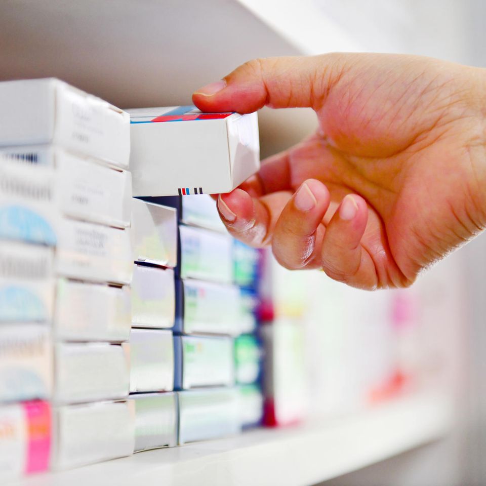 Gelenkschmerzen-Hausmittel: Eine Hand nimmt eine Medikamenten Verpackung aus dem Regal