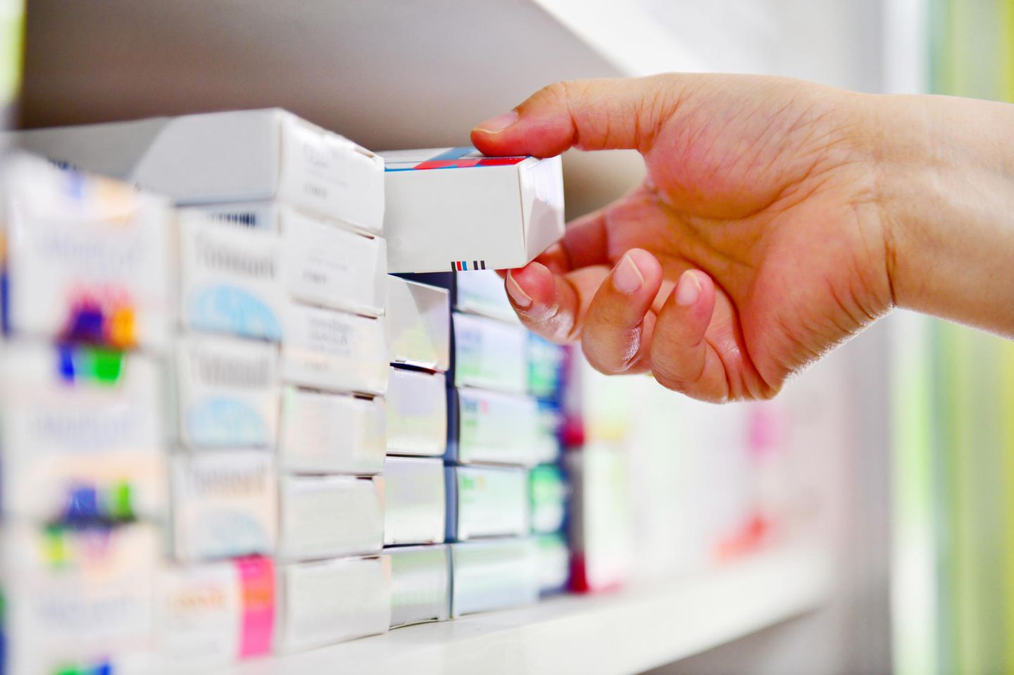 Gelenkschmerzen-Hausmittel: Eine Hand nimmt eine Medikamenten Verpackung aus dem Regal