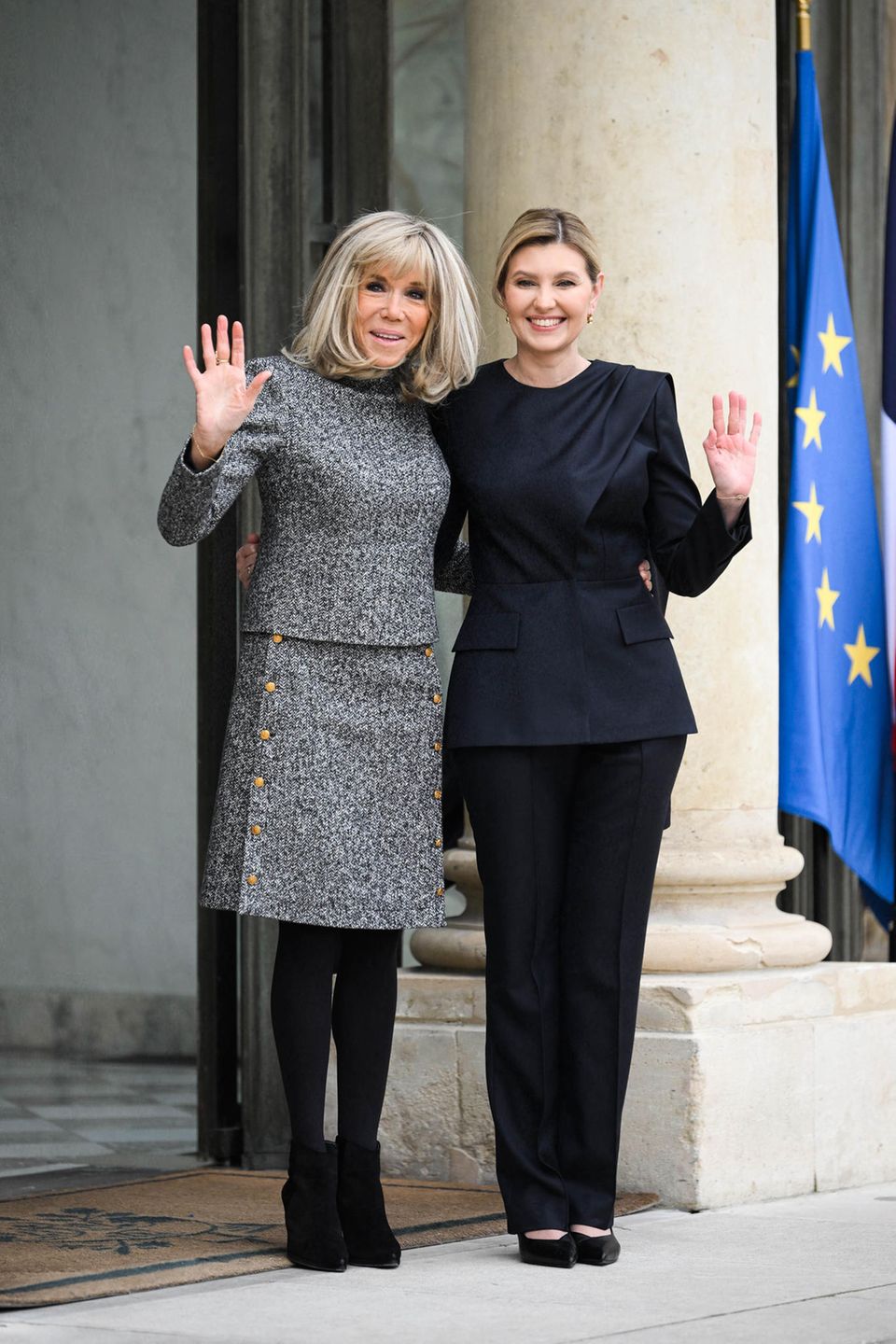 Brigitte Macron empfängt Olena Selenska in Paris. Sie setzt auf ein Kostüm, das ihre Vorzüge hervorhebt: Der knielange Rock ist gerade geschnitten, was sie optisch streckt, kleine goldene Knöpfe bringen zusätzlich etwas Glamour in das Outfit. 