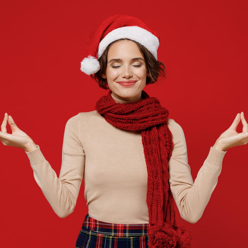 Weihnachtsstress vermeiden: Entspannte Frau mit Weihnachtsmütze