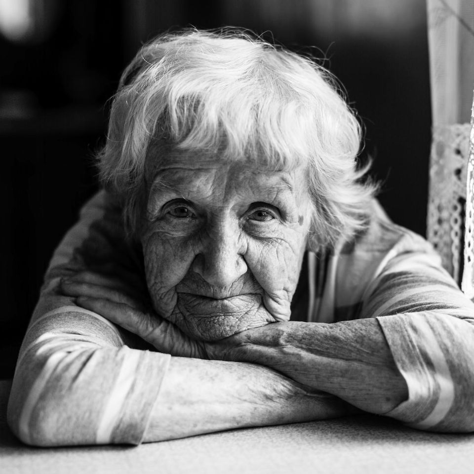Eine ältere Frau schaut in die Kamera (schwarz-weißes Porträt)