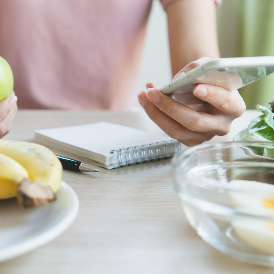 Noom: Frau hat ihr Handy in der Hand