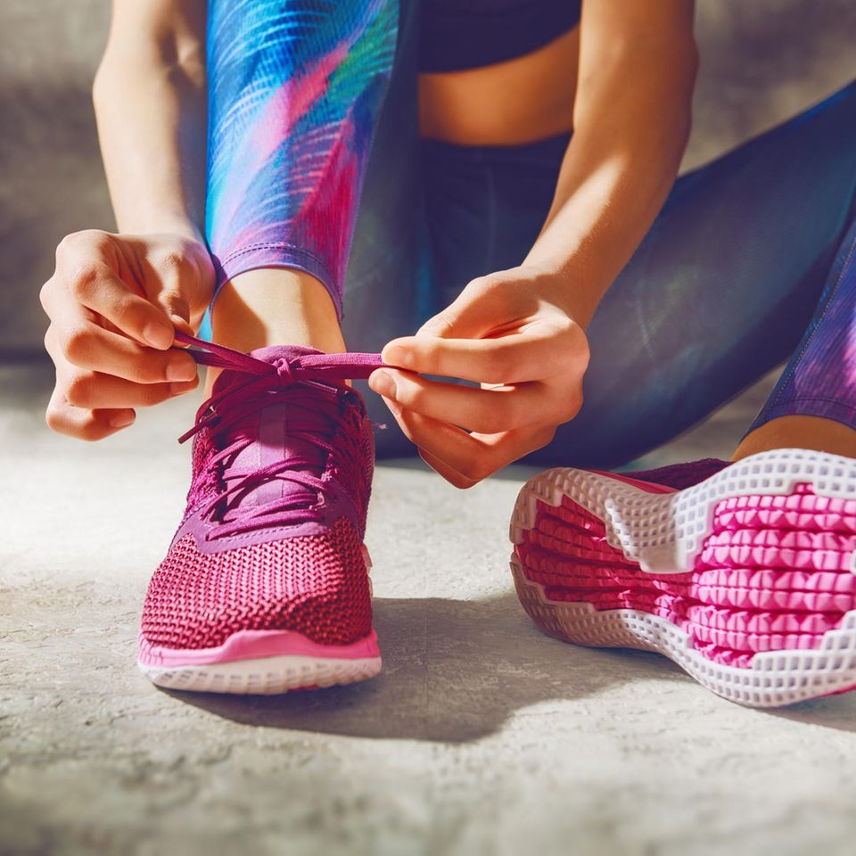 Abnehmen: Frau schnürt Sportschuhe