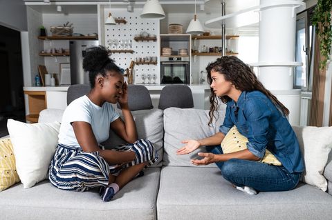 Frauen streiten auf der Couch: 5 unnötige Sätze, die jede Beziehung vergiften