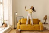 "Decluttering"-Trend: Frau hört Musik und tanzt auf dem Sofa