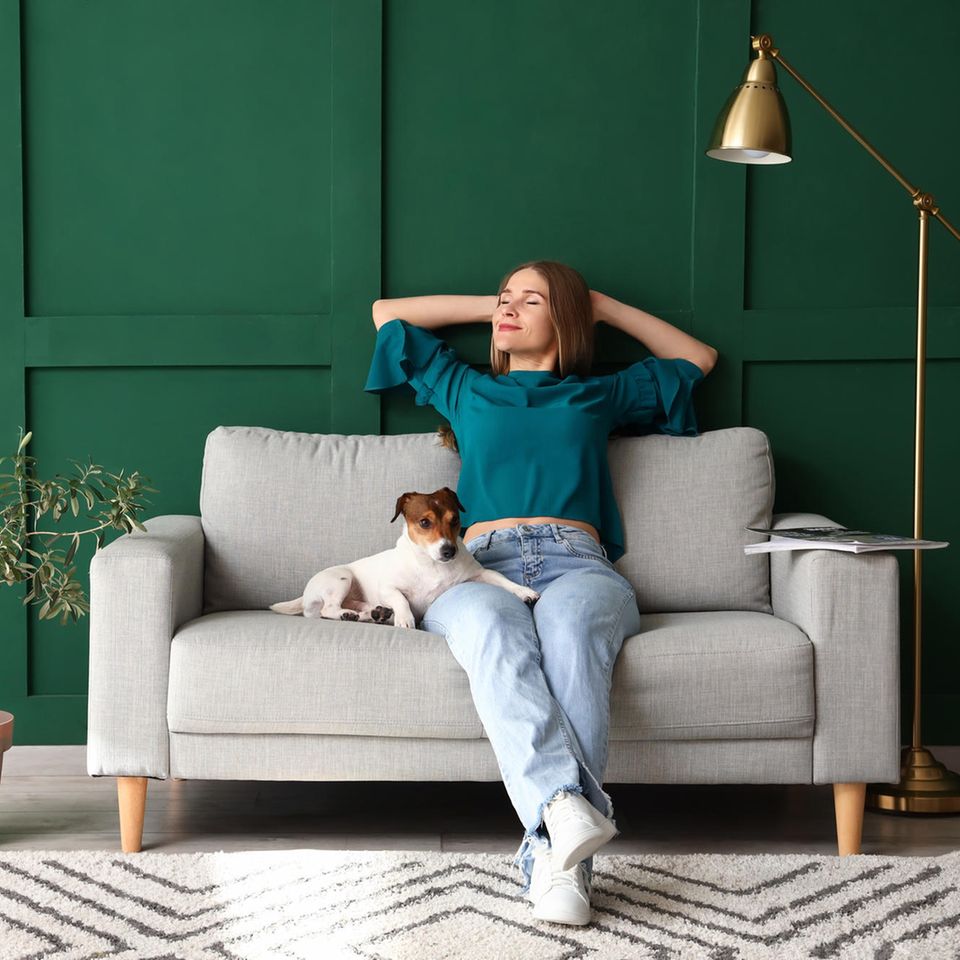 Frau in gemütlichem Wohnzimmer mit Hund: 5 Einrichtungstipps, die dein Wohlbefinden steigern