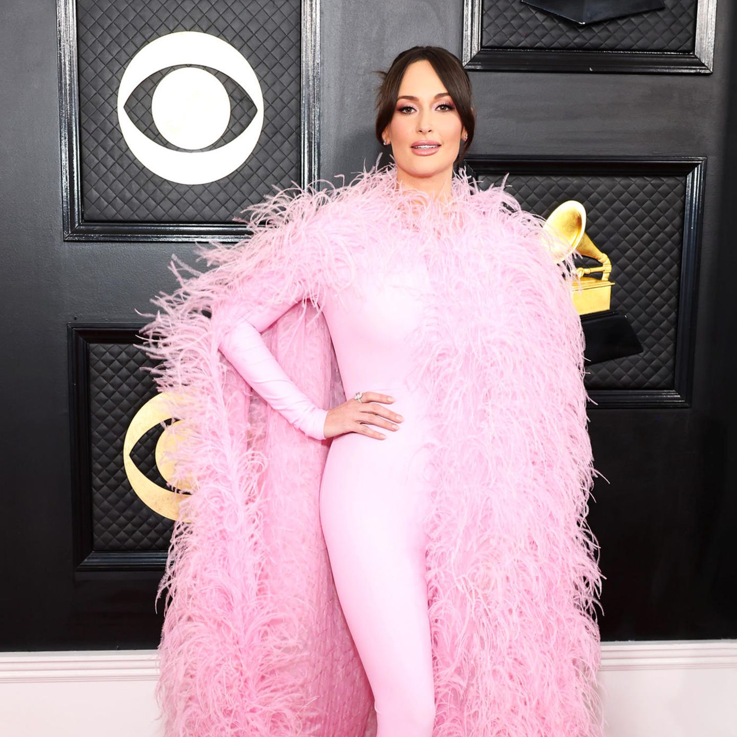 Country-Star Kacey Musgraves schwebt im rosafarbenen Feder-Look über den roten Teppich der Grammys.