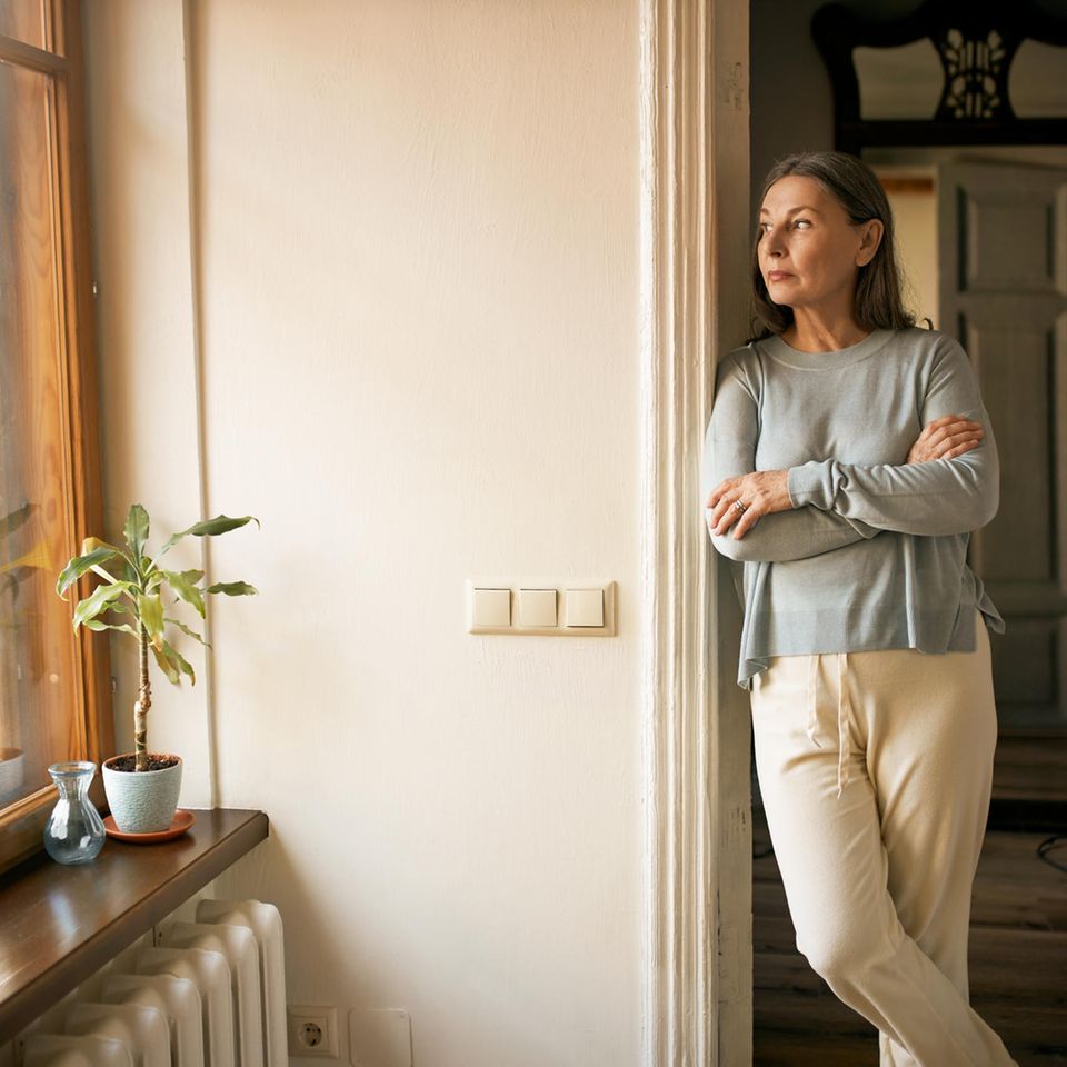 Frau schaut aus dem Fenster: 4 Zeichen, dass du eine toxische Beziehung zu dir selbst hast