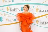 In London sorgt Florence Pugh in einem orangefarbenen transparenten Kleid von Nina Ricci für einen WOW-Moment. Ihr Haarstyle orientiert sich stark an ihrem Kleid und greift die Rüschen wieder auf. Diamanten-Schmuck und ein silberner Nasenring sorgen für einen interessanten Stilbruch.