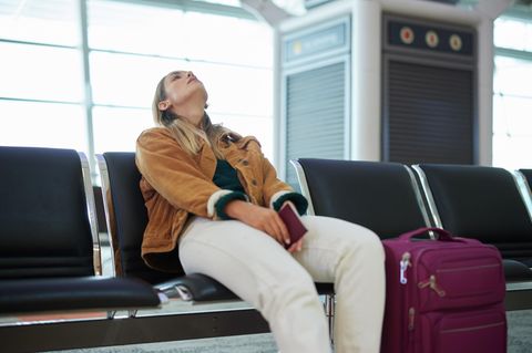 Erschöpfte Frau an einem Flughafen