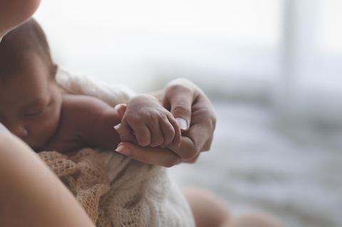 Ein Neugeborenes im Arm von Mama