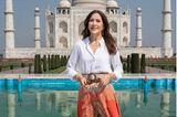 Für ihren Besuch beim Taj Mahal im Rahmen einer offiziellen Reise nach Indien hat sich Kronprinzessin Mary für einen gemusterten Maxirock und eine weiße Bluse entschieden. Dazu kombiniert sie einen breiten Gürtel und goldenen Schmuck der Marke DULONG. Mit diesem leichten Outfit ist Mary perfekt für die heißen Temperaturen Indiens gewappnet. 