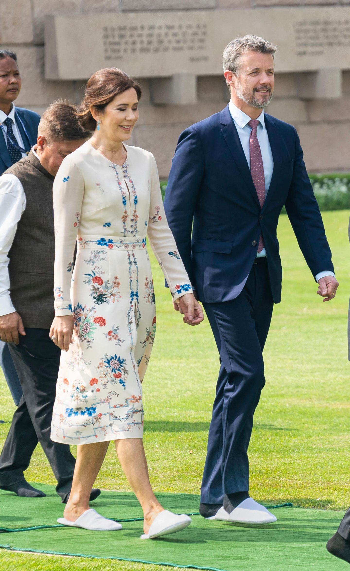 Neben dem floralen Kleid ist auch Prinzessin Marys Schuhwahl ein echter Hingucker. Die Kronprinzessin trägt an ihrem zweiten Tag der Indien-Reise weiße Slipper. Aber auch Prinz Frederik musste sich wohl zu seinem Anzug in weiße Hausschuhe schmeißen.