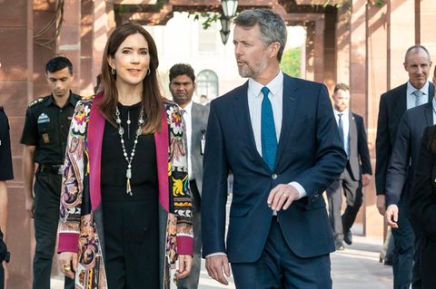 Bei ihrem Besuch im Präsidentenpalast im Rahmen ihrer Indien-Reise trägt Kronprinzessin Mary von Dänemark einen bunten Kimono-Mantel von Etro. Zu dem ansonsten schlichten schwarzen Outfit kombiniert sie spitze Pumps von Gianvito Rossi. Ihr Mann entscheidet sich gegen schrille Muster und trägt einen eleganten blauen Anzug. 