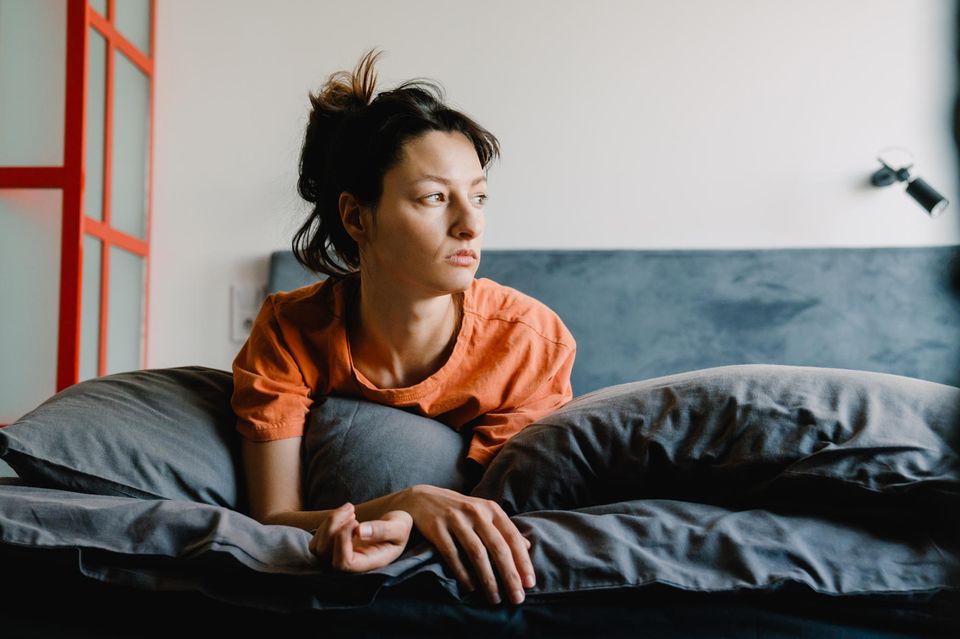 Erholungstyp: Frau sitzt müde im Bett