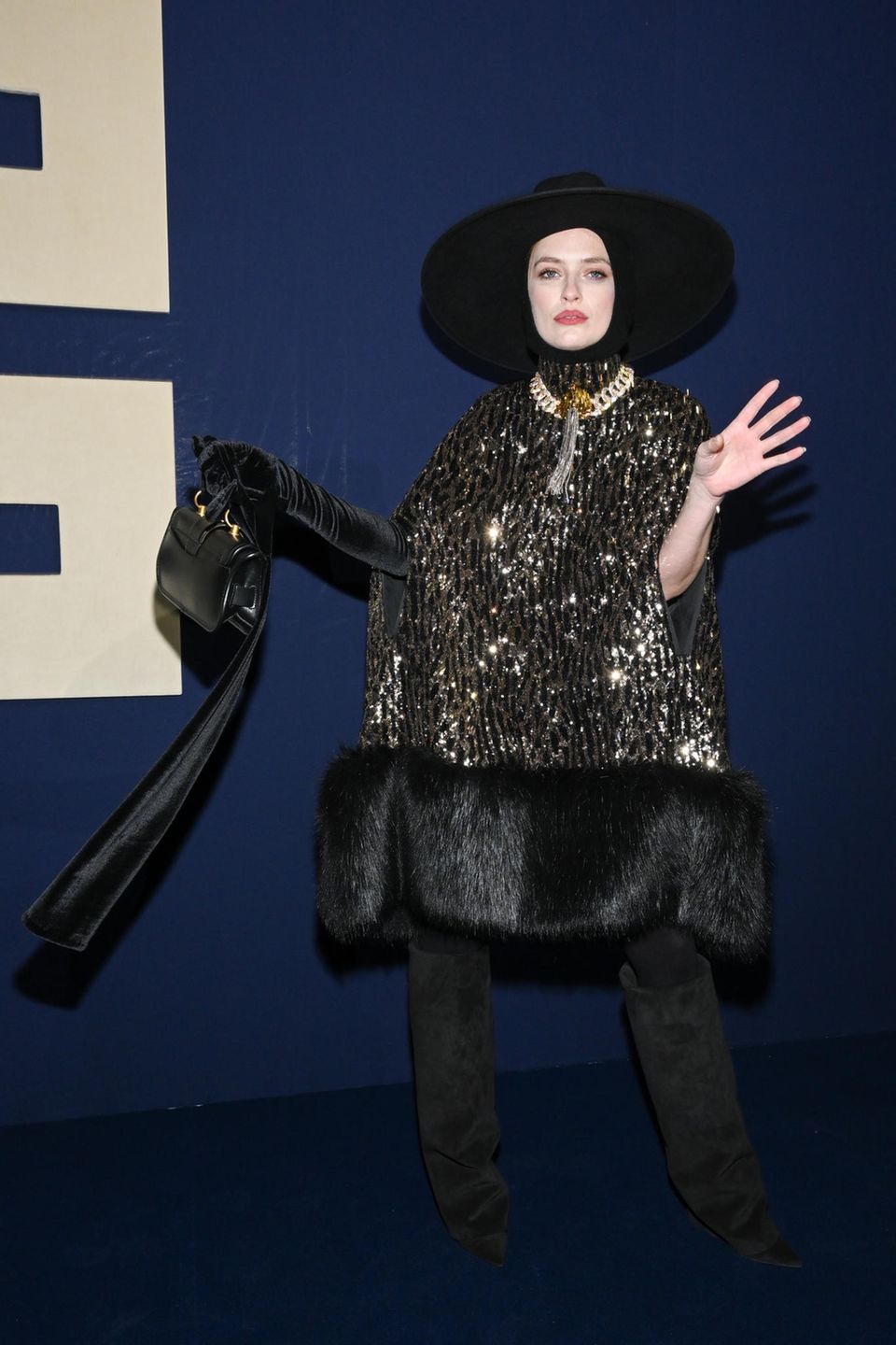 Schon alleine ihr Auftritt ist ein Kunstwerk: "Emily in Paris"-Star Camille Razat zeigt sich bei Balmain ein einem punkvollen Outfit aus XL-Hut, dicker Gliederkette und glitzernder Bluse. 