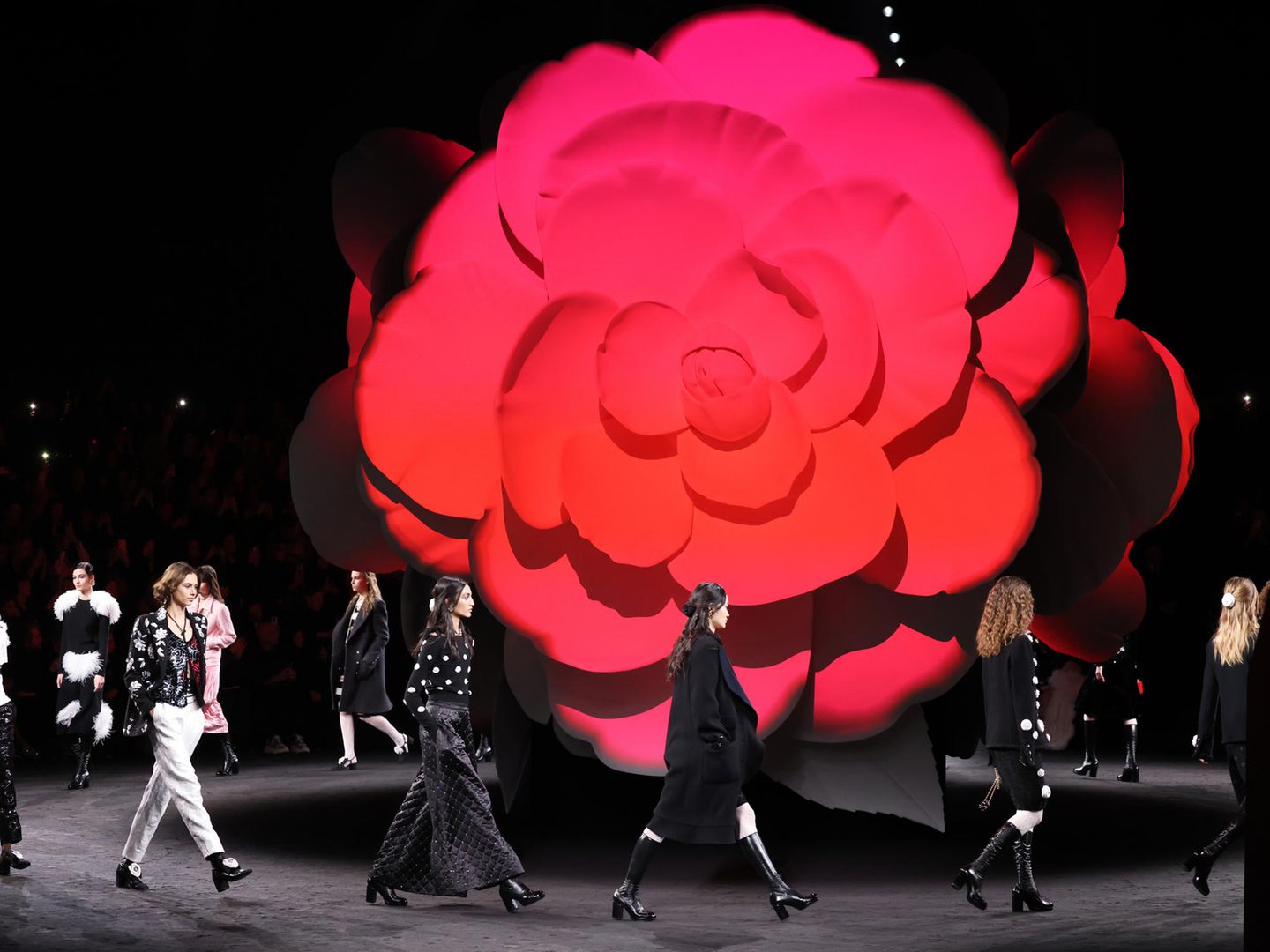 Die Chanel-Show zur Herbst/Winter Kollektion findet im Grand Palais Éphémère in Paris statt. Der Hintergrund des Laufstegs wird von einer überdimensionale Kamelie geschmückt. Die Kamelie gilt als typisches Chanel-Motiv und findet sich auch in der neuen Kollektion wieder.