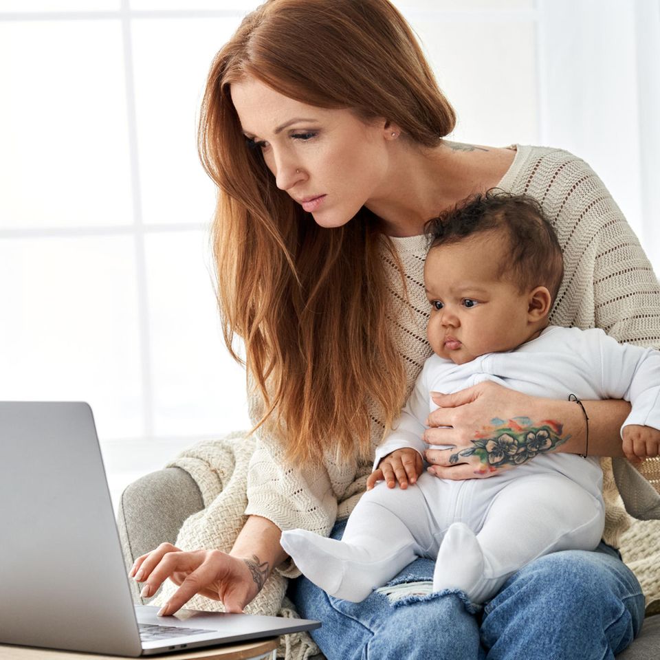 Macherinnen: Eine junge Frau sitzt mit einem Baby auf dem Schoß vor dem Laptop