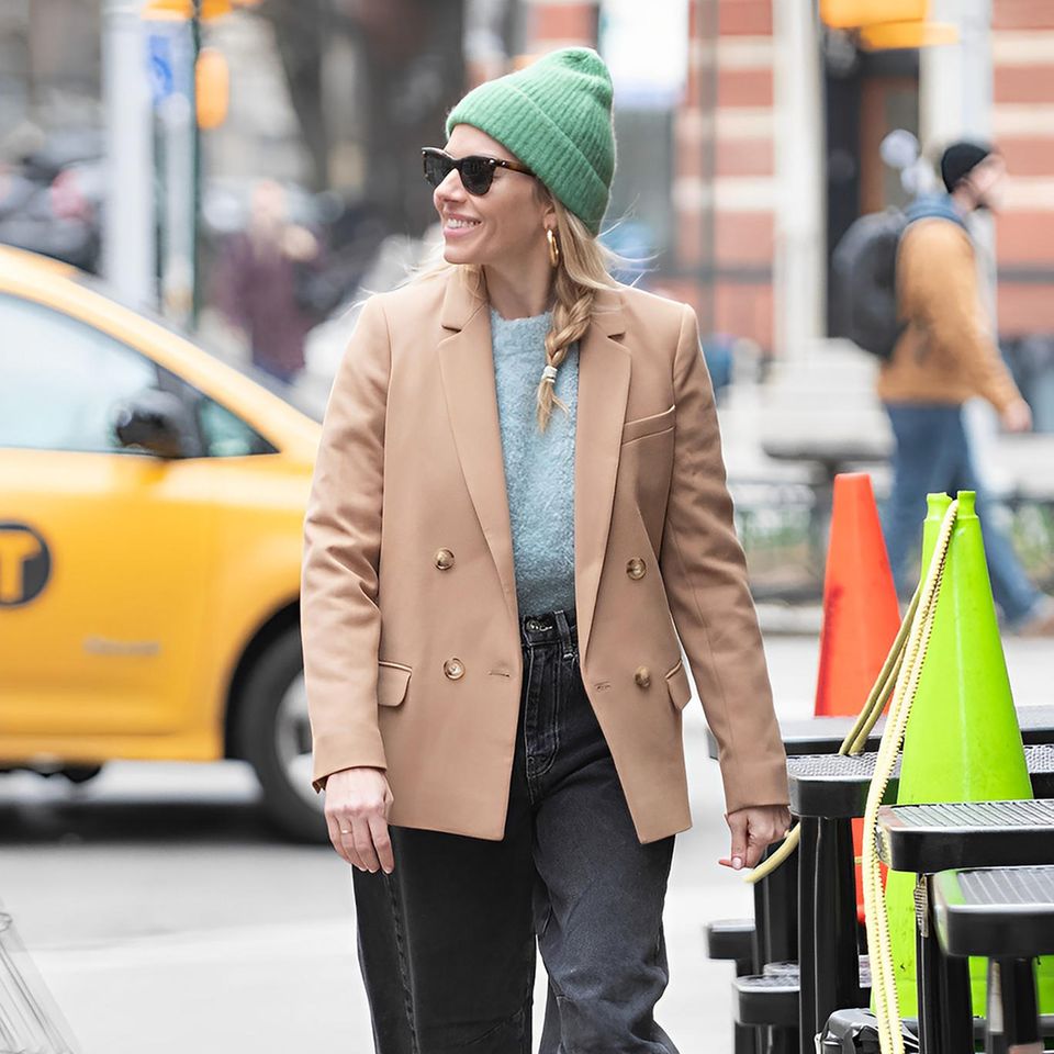 Sienna Miller überzeugt beim Winterspaziergang in New York mit einem lässigen Kuscheloutfit. Zur grünen Wollmütze stylt die Schauspielerin Jeans, Blazer – und einen Hingucker-Pullover von Mango in Blau. Der ist nicht nur Highlight ihres Styles, sondern beweist auch, dass coole Pieces überhaupt nicht teuer sein müssen. 