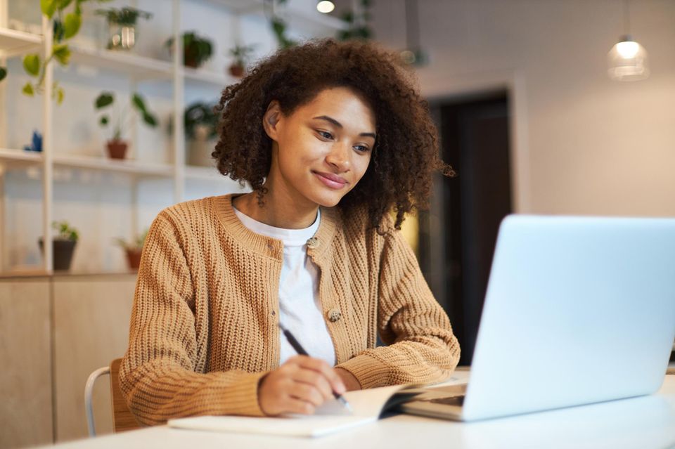 Job Crafting: Frau sitzt vor einem Laptop und arbeitet