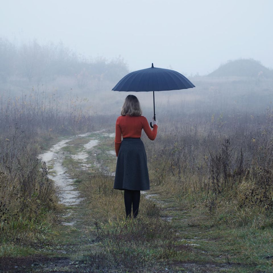 Frau steht im Regen: Diese selbstzerstörerischen Denkmuster sollten wir uns abgewöhnen