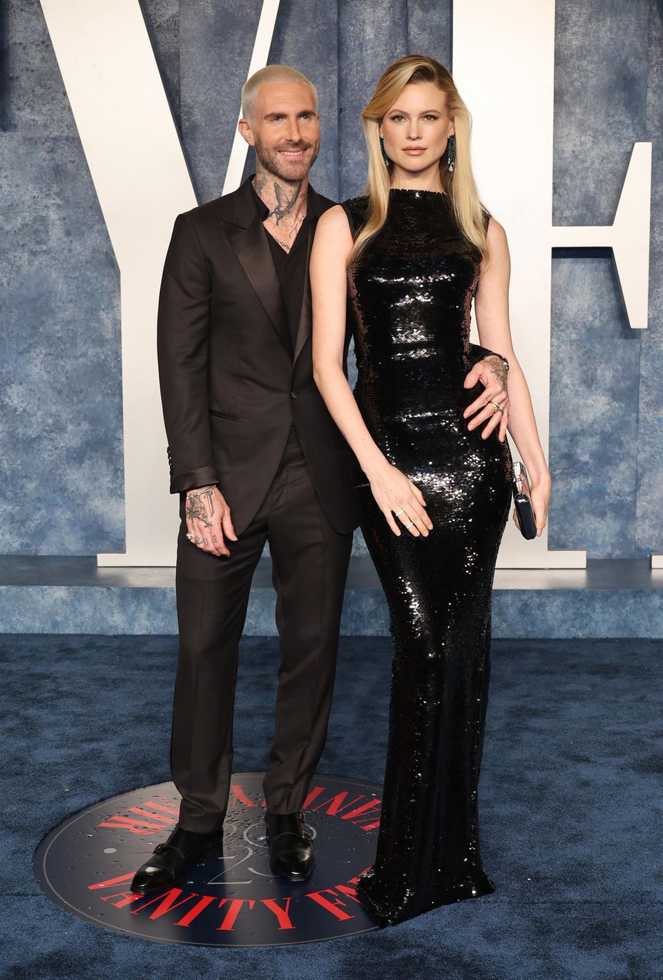 Bei ihrem Couple-Auftritt auf der Oscar-Aftershow-Party strahlen Behati Prinsloo und Adam Levine in einem all-black-Outfit. Während der Sänger auf einen schwarzen Anzug setzt, trägt das Model ein körperbetontes Pailletten-Kleid. 