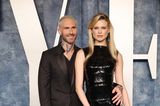 Bei ihrem Couple-Auftritt auf der Oscar-Aftershow-Party strahlen Behati Prinsloo und Adam Levine in einem all-black-Outfit. Während der Sänger auf einen schwarzen Anzug setzt, trägt das Model ein körperbetontes Pailletten-Kleid. 