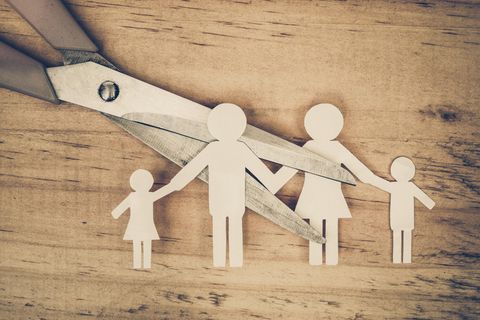 Trennung mit Kindern: Schere zerschneidet Papierfiguren einer Familie