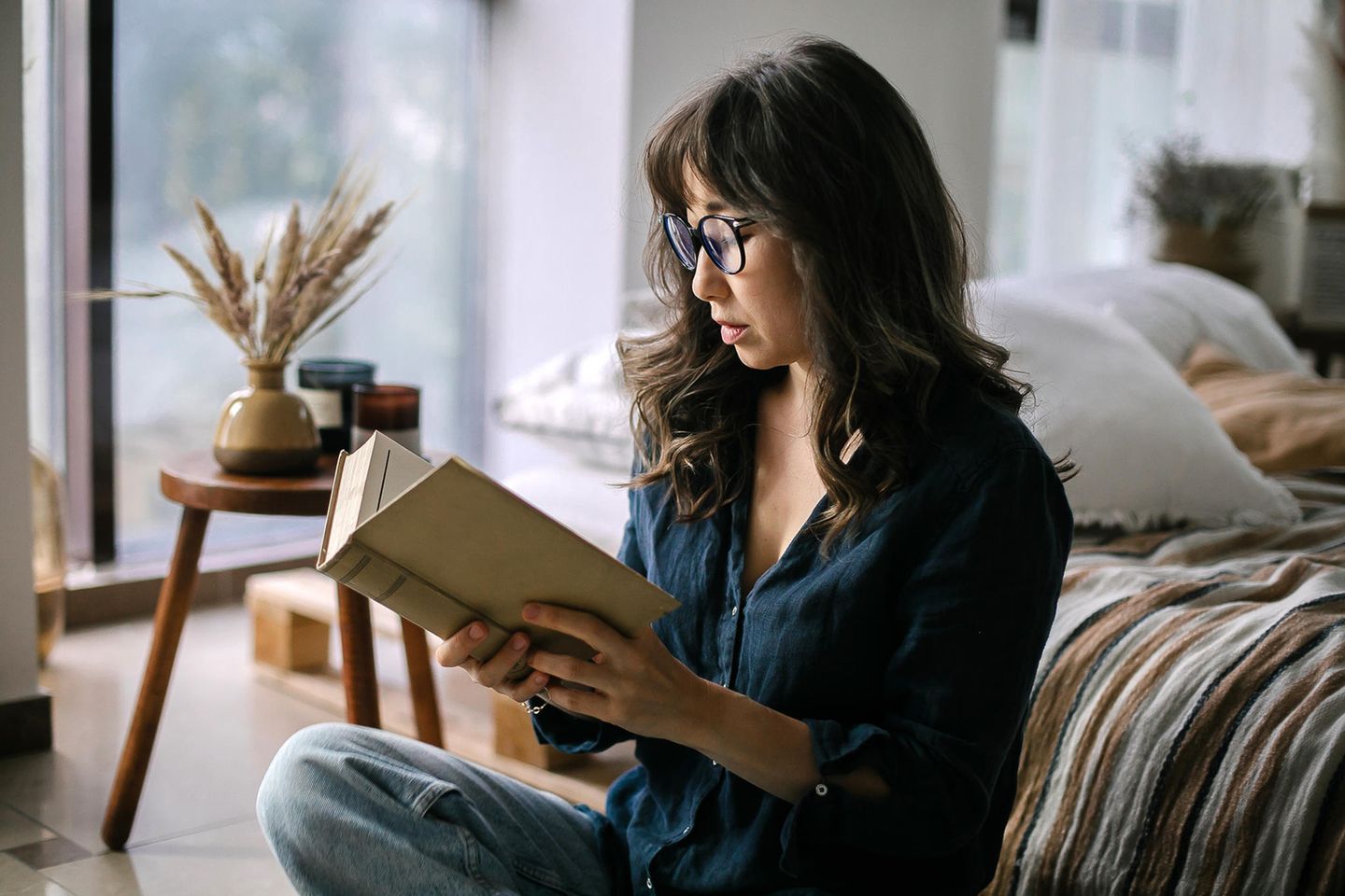Frau liest gespannt ein Buch: 5 Bücher, die dich zum Nachdenken anregen werden