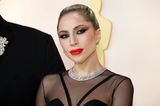 Hier weiß man gar nicht, wo man zuerst hinschauen soll! Lady Gaga überrascht bei dem Oscars mit starken Konturen und umso betonteren Kieferknochen. Auch das intensiv schwarze Reverse Cat-Eye und rote Latexlippen unterstreichen das schmale Gesicht der Oscar-Preisträgerin.