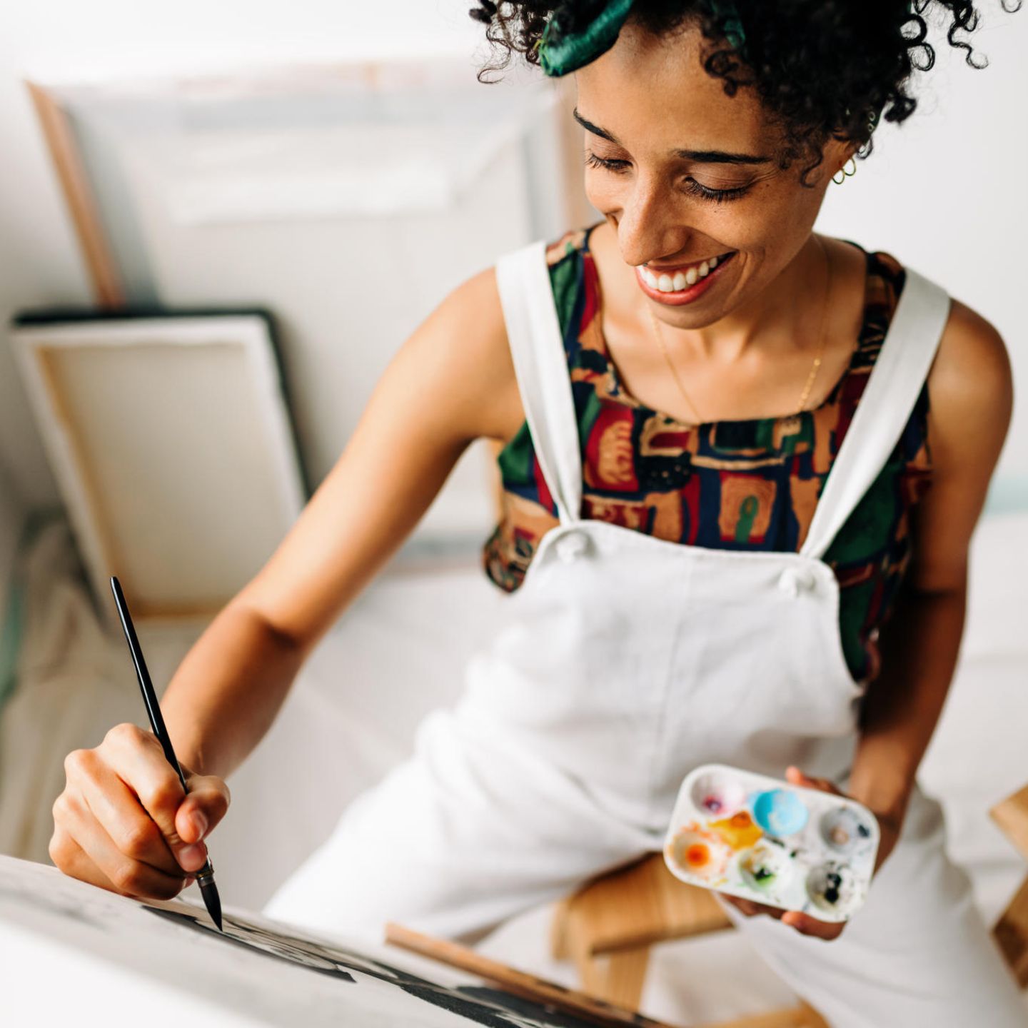 Eine Frau malt glücklich auf einer Leinwand