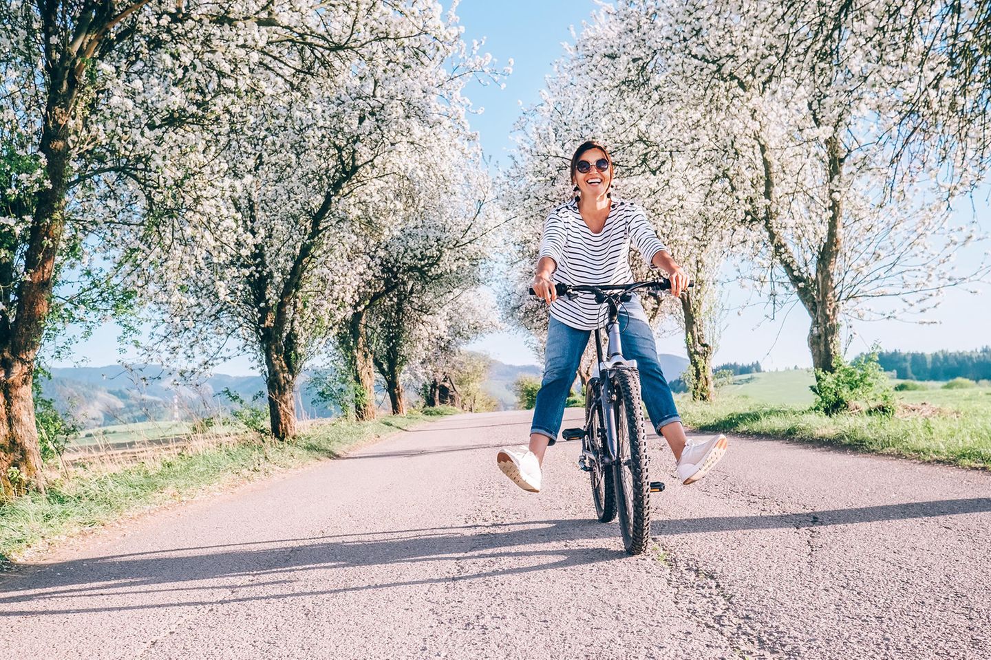Frau fährt im Frühling Fahrrad: 4 Rituale, um den Frühling zu begrüßen